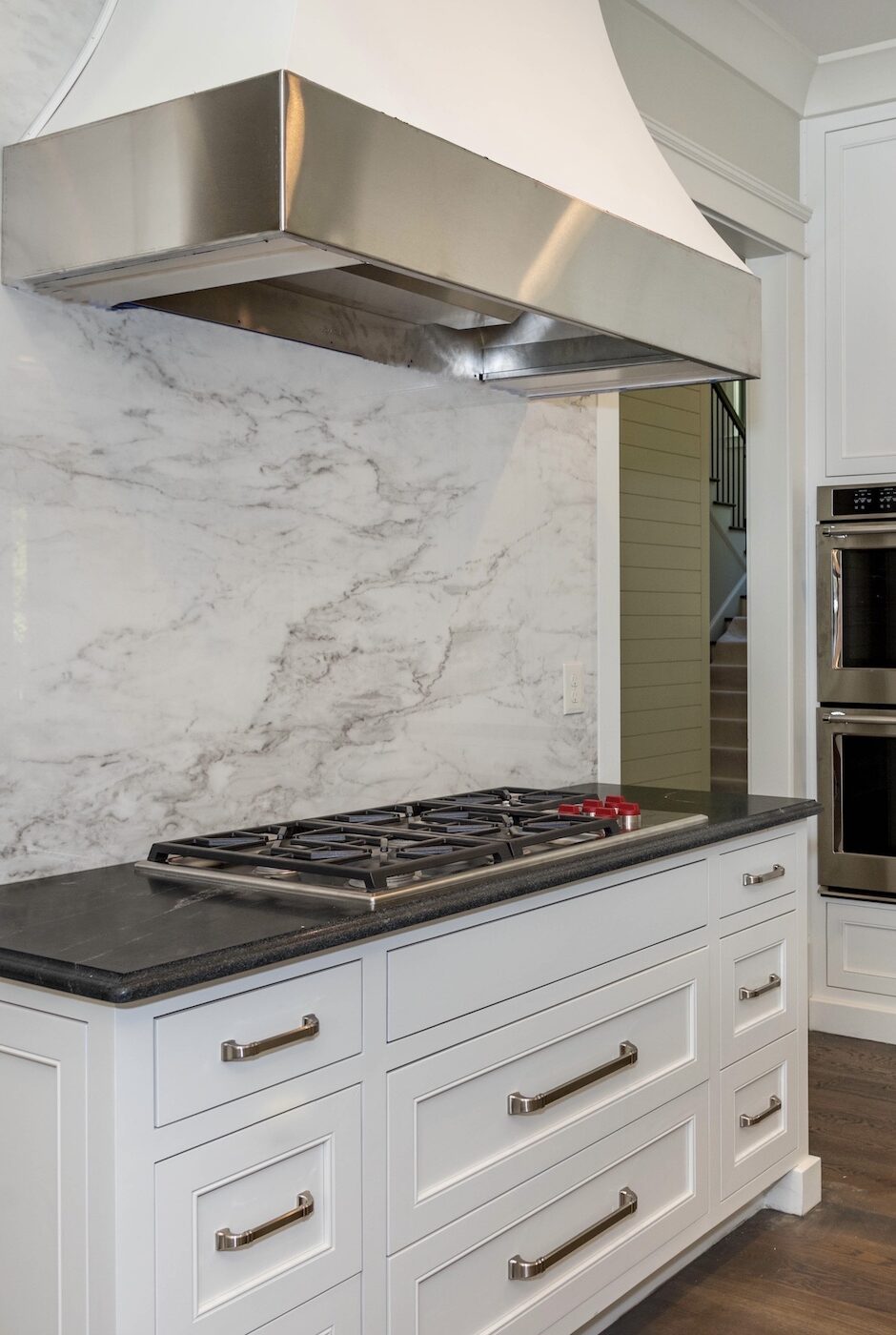 kitchen-oven-range-detail-white-cabinetry-marble-backsplash